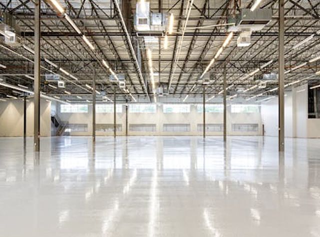 An Empty Warehouse Featuring White Floors And A White Ceiling, Creating A Spacious And Bright Environment